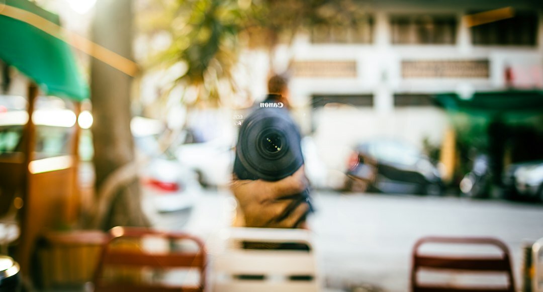 Young journalist holding a professional video camera outdoors in an urban street